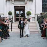 bride and groom walking out of the building