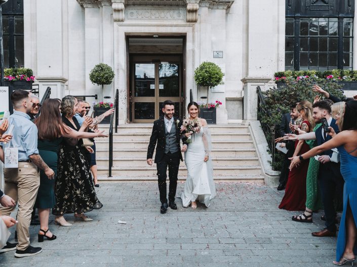 bride and groom walking out of the building